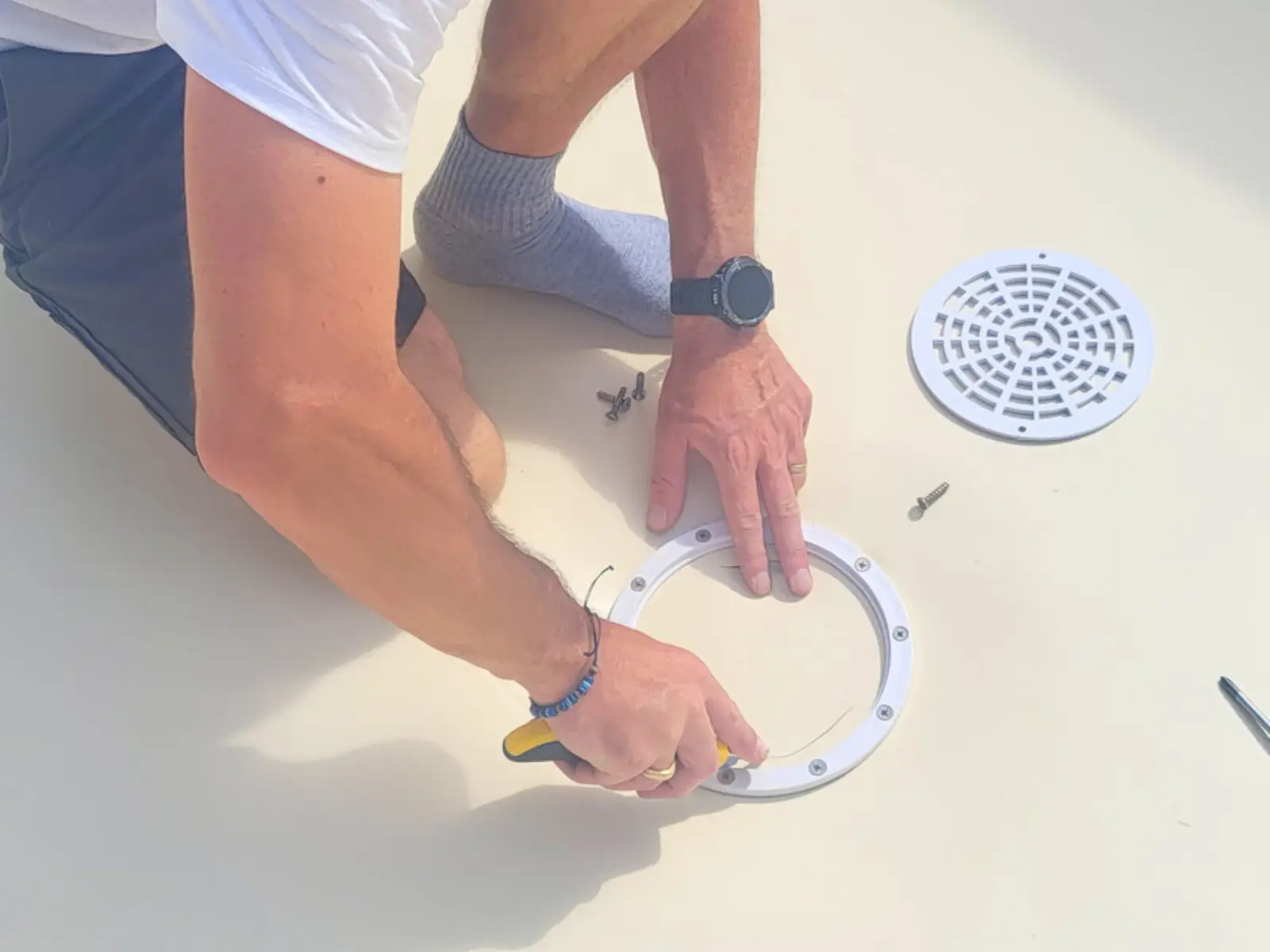Technicien Hydrotec installant la bonde de fond sur un liner neuf lors de la rénovation d'une piscine