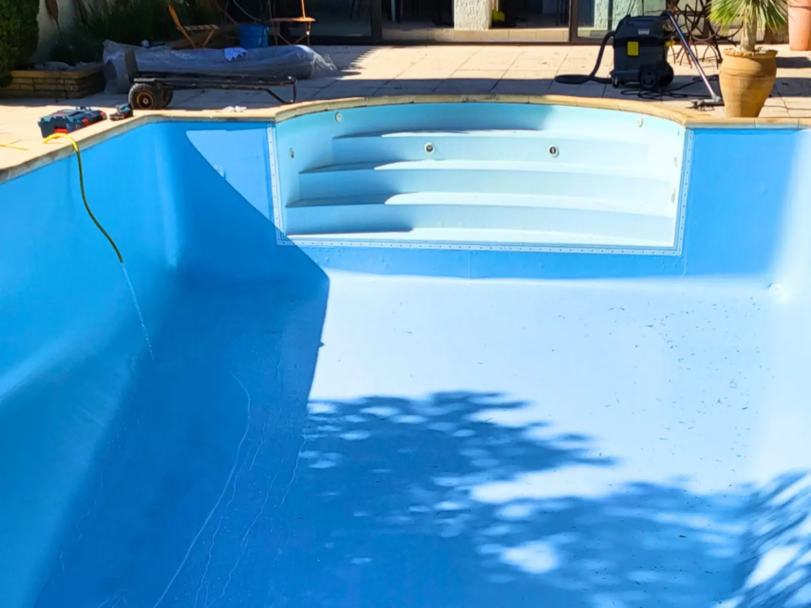 Piscine rénovée avec nouveau liner bleu clair et escalier intégré réalisée par Hydrotec Piscine & SPA